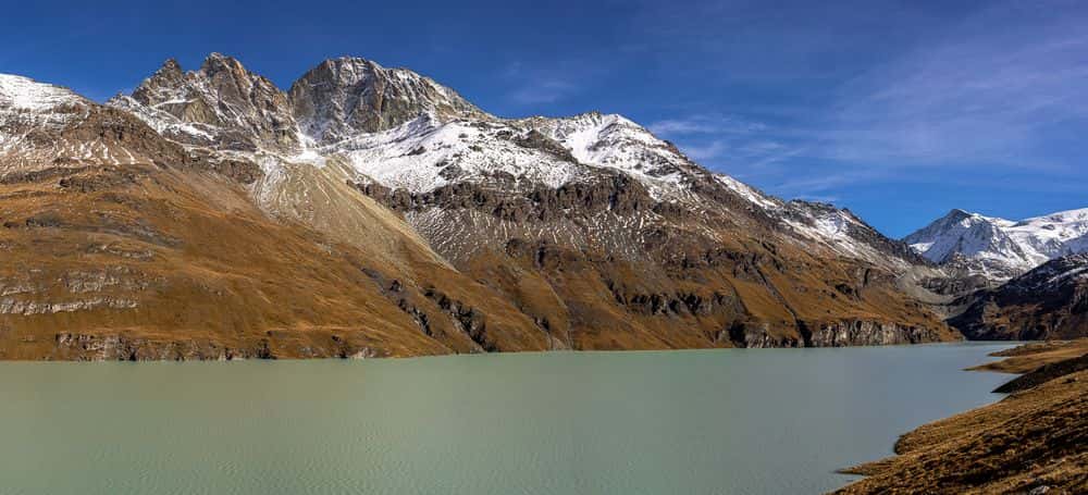 The emerald green water of Lac des Dix shines in the otherwise rugged mountain landscape.
